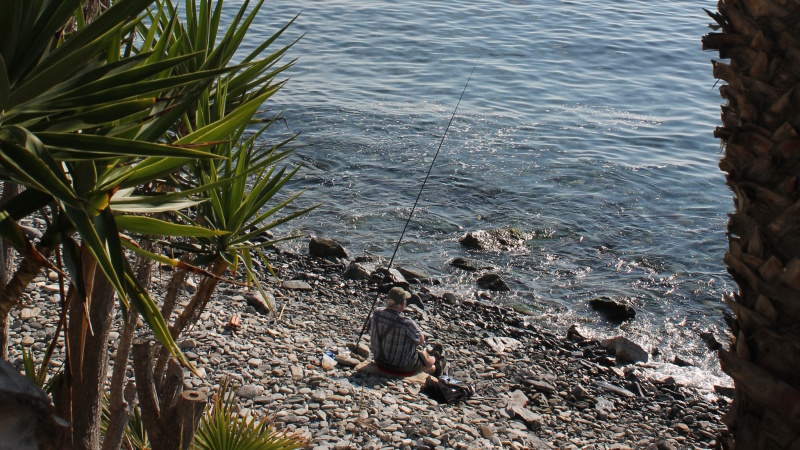 Fiskare pa klapperstensstrand i Almunecar